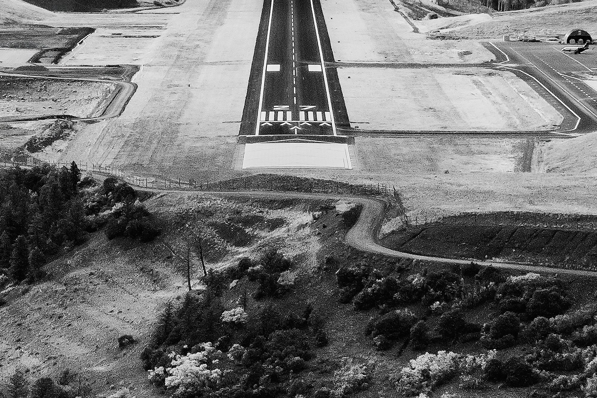 Aerial view of an airport runway surrounded by natural landscape