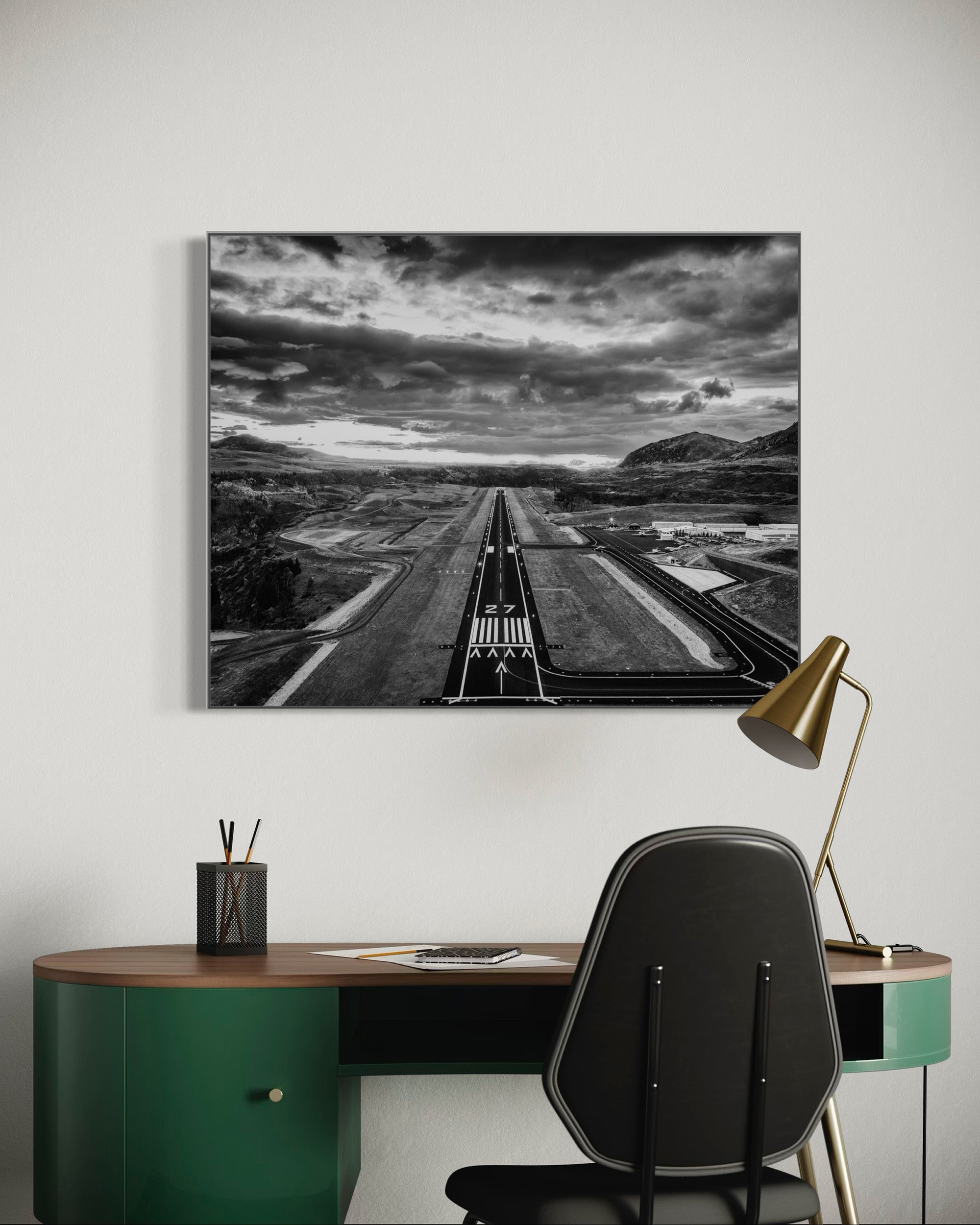 Modern office with a large framed photograph of Telluride runway 27 with mountains above a desk