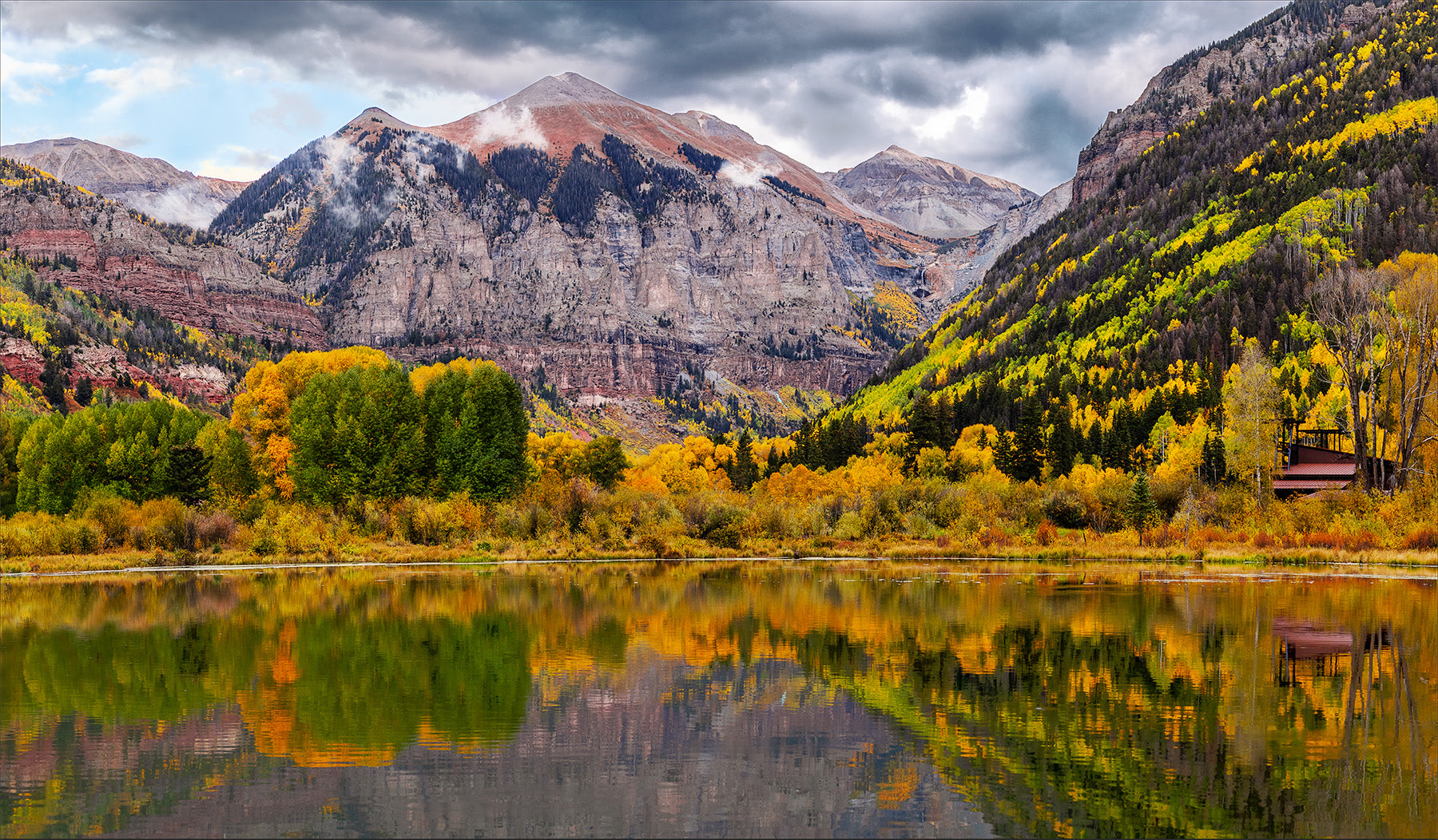 Ajax peak reflecting in town beaver pond in telluride with reflections with concert venue in background