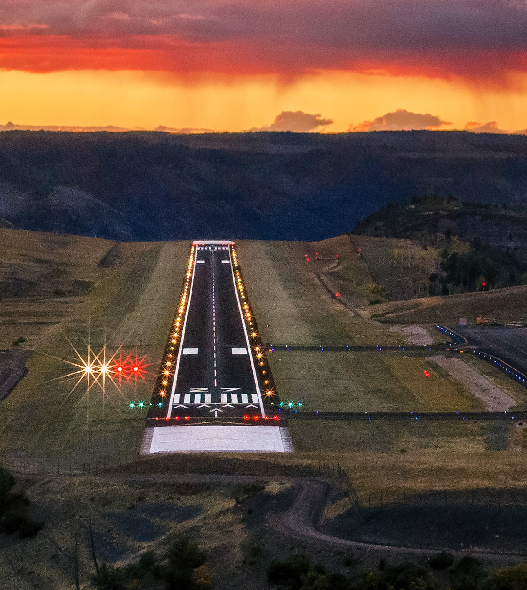 Aerial view of Telluride airport at sunset with runway lights on