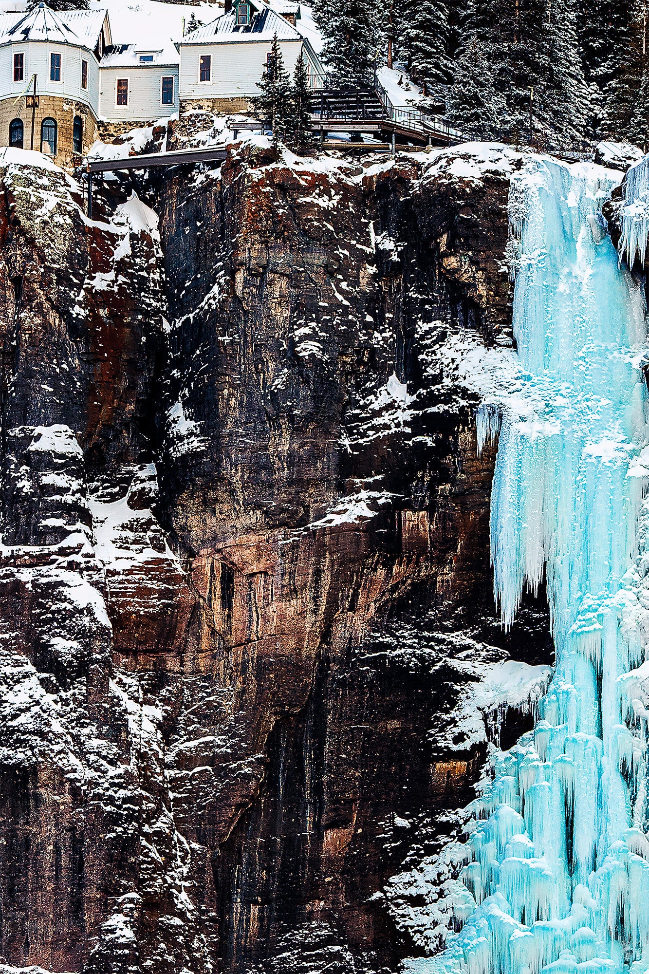 Frozen waterfall closeup of bridal veil falls snow-covered cliffs, electricity station 